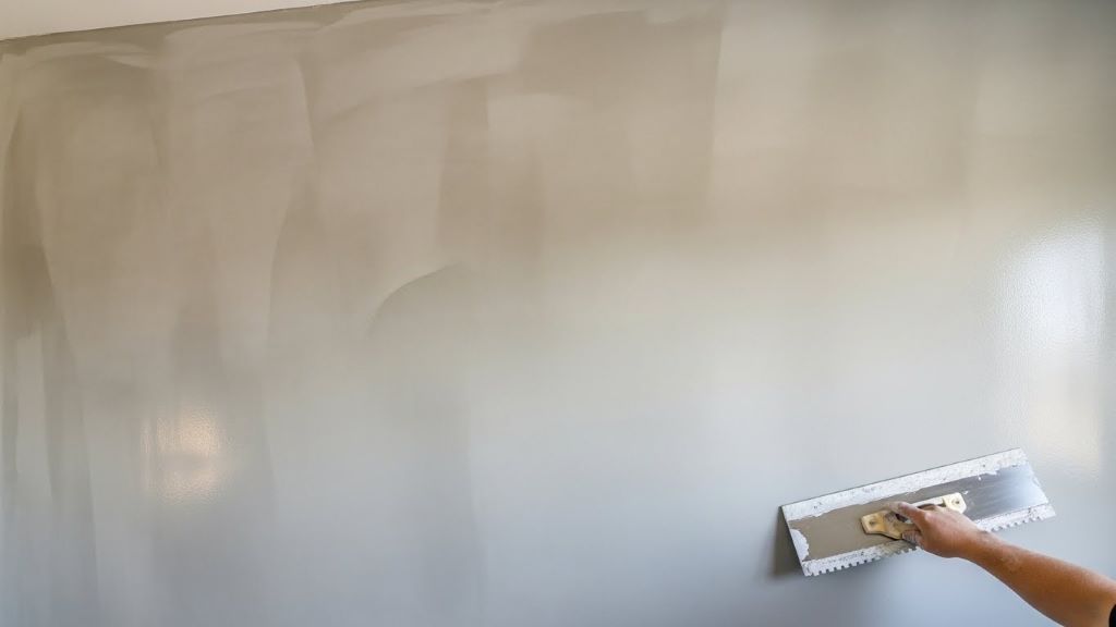 Smooth base coat application on drywall surface before decorative texturing process