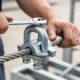 Person installing rope clamp on steel cable with wrench