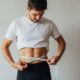 Man measuring waist for cycling shorts sizing guide