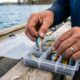 Open tackle box neatly organized with colorful fishing lures in compartments.