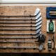 A set of clean golf clubs and maintenance tools on a wooden workbench.